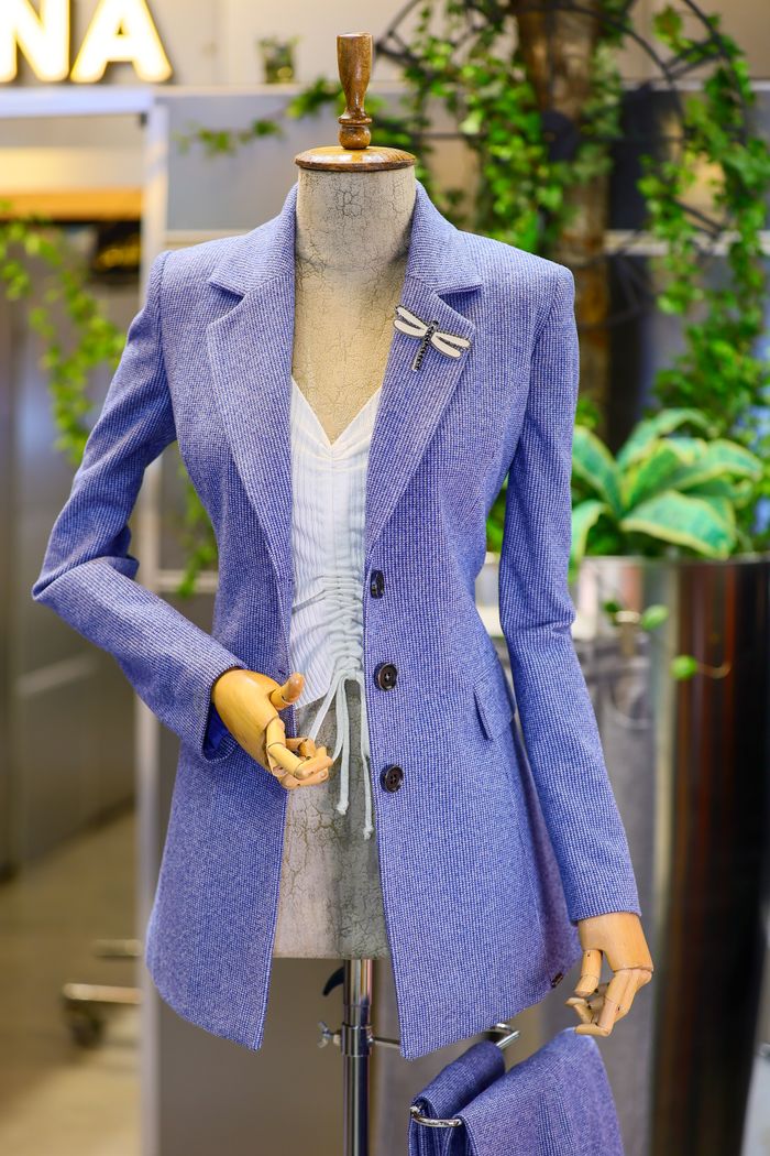 about-01 Elegant lilac jacket on a mannequin in boutique setting, showcasing chic fashion.
