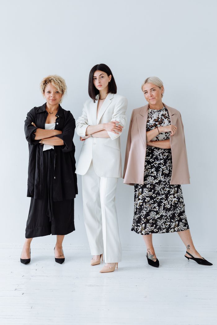 gallery-1 Three diverse women in stylish outfits posing confidently in a studio shoot on a white background.